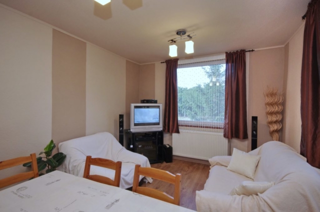 Nappali szoba kanappéval, karosszékkel, TV-sarokkal a gyulai Bodza apartmanban