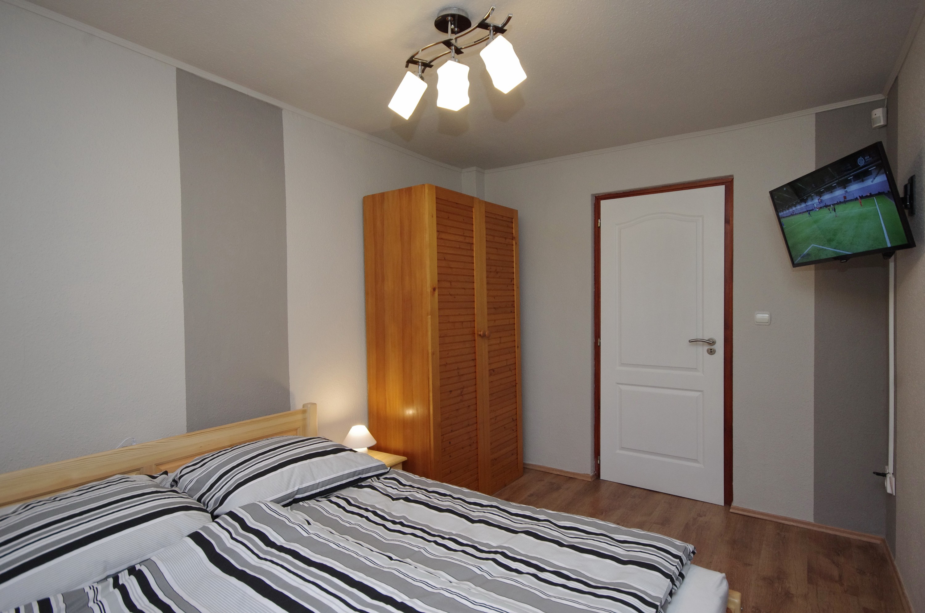 Téli szoba kétszemélyes ággyal, szekrénnyel és TV-vel a gyulai Bodza apartmanban